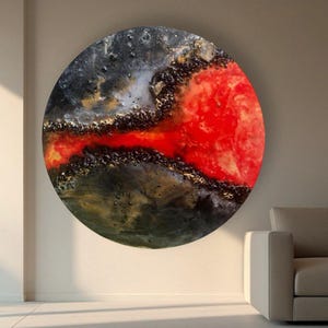 May include: Abstract circular painting with a black, gold, and red color scheme. The red paint appears to be flowing through the black and gold paint.