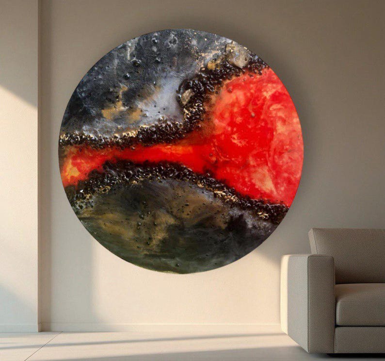 May include: Abstract circular painting with a black, gold, and red color scheme. The red paint appears to be flowing through the black and gold paint.