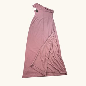 Puede incluir: Vestido largo asim&eacute;trico rosa empolvado con una abertura alta. El vestido presenta un escote drapeado y un corpi&ntilde;o entallado. Una etiqueta est&aacute; adjunta. El vestido est&aacute; hecho de una tela suave y fluida.
