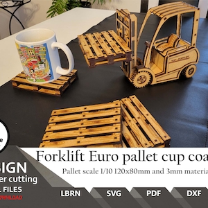 May include: A laser-cut wooden forklift model and several miniature pallet coasters. One coaster supports a white ceramic mug with a colorful city illustration. The text reads Forklift Euro pallet cup coasters, Pallet scale 1/10 120x80mm and 3mm material, LBRN, SVG, PDF, DXF, AI.