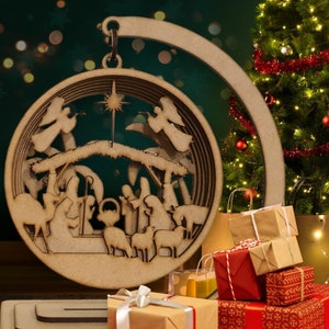 May include: A wooden Christmas ornament depicting the nativity scene. The ornament is a circle with a cutout design of the manger, Mary, Joseph, baby Jesus, and the three wise men. The ornament is hanging from a wooden hook.