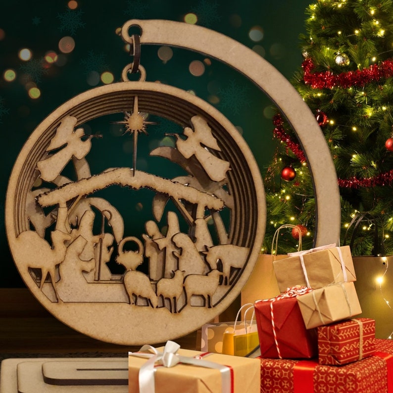 May include: A wooden Christmas ornament depicting the nativity scene. The ornament is a circle with a cutout design of the manger, Mary, Joseph, baby Jesus, and the three wise men. The ornament is hanging from a wooden hook.