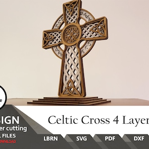 May include: A multi-layered wooden Celtic cross featuring intricate knotwork patterns and a circular halo design. The structure is composed of four distinct stacked layers with cut-out details, mounted on a tiered rectangular base. Text reads Celtic Cross 4 Layers.