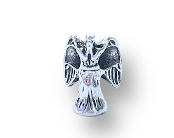 May include: Silver charm featuring a detailed angel with outstretched wings. The angel is standing on a base and has a crown on its head.