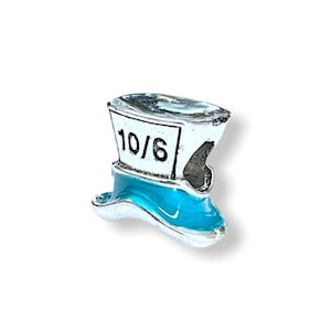 May include: A silver charm in the shape of a blue and white top hat with the number 10/6 on the front.