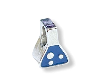 May include: A silver-colored charm in the shape of a laboratory flask. The flask has a blue enamel design on the bottom with three white circles. The charm has a hole at the top for attaching to a bracelet or necklace.