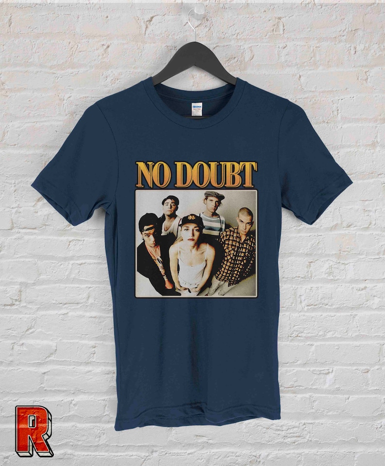 May include: A navy blue t-shirt with a vintage-style graphic of the band No Doubt. The graphic features a photo of the band members, including Gwen Stefani, Tony Kanal, Adrian Young, Tom Dumont, and Eric Stefani.