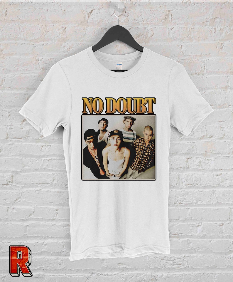 May include: White t-shirt with a vintage-style graphic of the band No Doubt. The graphic features a photo of the band members, including Gwen Stefani, in black and white.