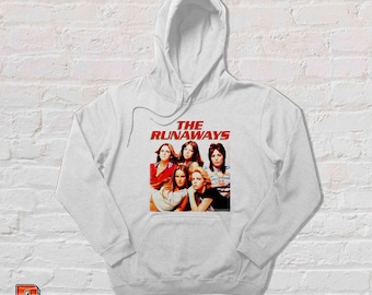 May include: White hoodie featuring a graphic of the band The Runaways. The image shows the band members with the band's name in red block letters. The hoodie has a front pocket and a drawstring hood.