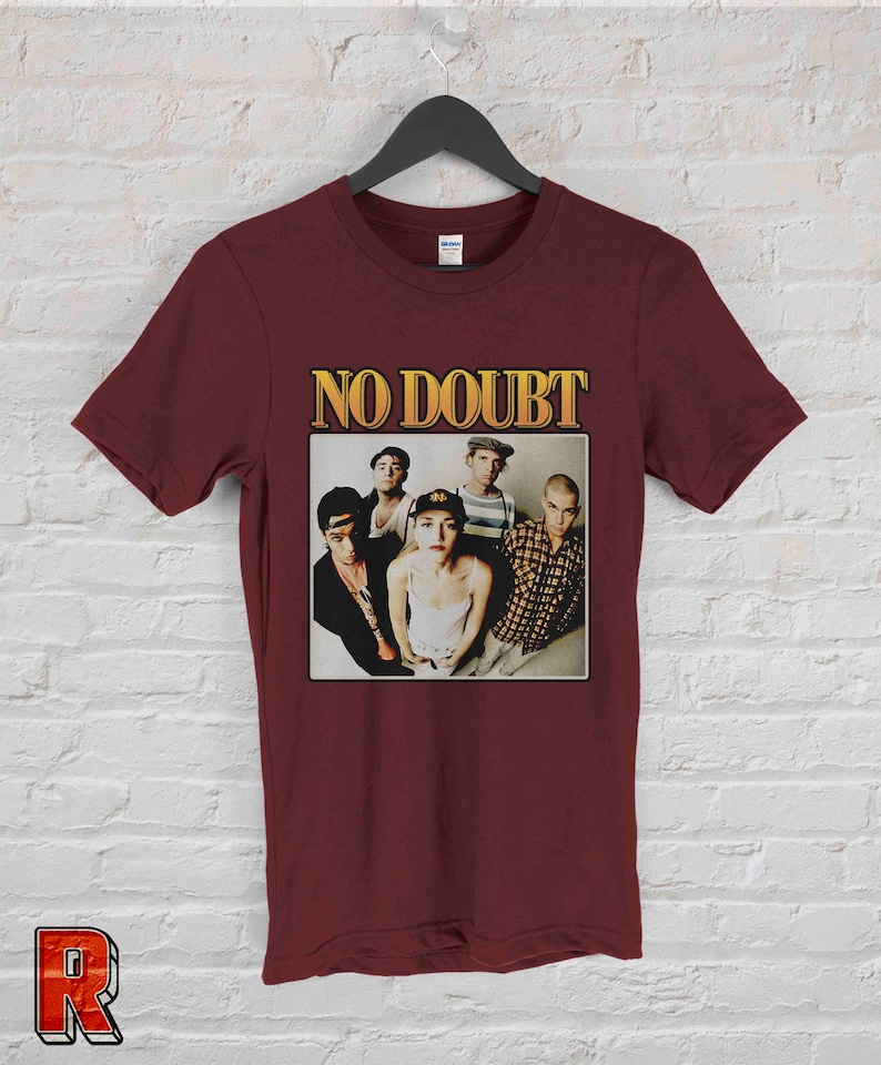 May include: A maroon t-shirt with a vintage-style image of the band No Doubt. The image features the band members in a group photo, with the band's name in gold lettering above them.