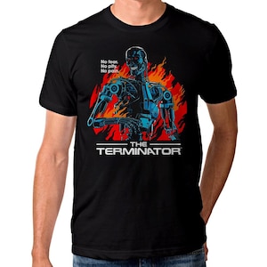 May include: Black t-shirt featuring a graphic of the Terminator robot in blue and red flames. The text "No fear. No pity. No pain." is above the robot, and "THE TERMINATOR" is below.