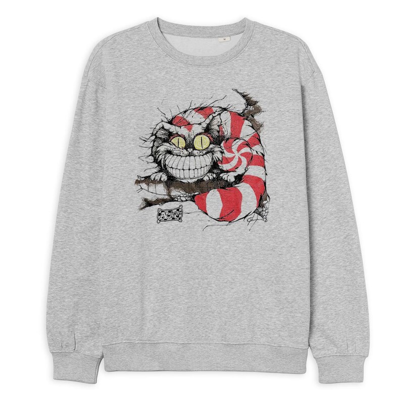 May include: A light gray sweatshirt featuring a graphic of the Cheshire Cat from Alice in Wonderland. The cat is depicted with red and white stripes, a wide grin, and yellow eyes. The design is a detailed illustration.
