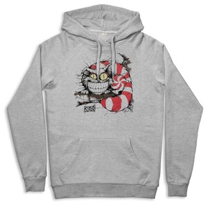 May include: A light gray hoodie featuring a graphic of the Cheshire Cat from Alice in Wonderland. The cat is smiling with a wide grin, and its tail is striped red and white. The hoodie has a front pocket and a drawstring hood.