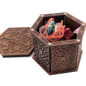 May include: A hexagonal wooden box with an intricate carved design, open to reveal colourful embroidery floss inside.