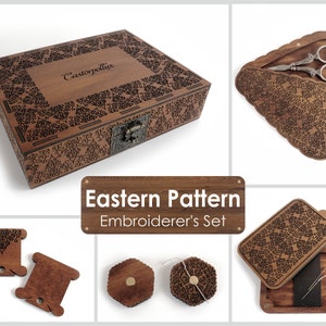 May include: A wooden embroidery set featuring an intricate Eastern pattern. The set includes a box, a needle case, two thread bobbins, and a pair of scissors. The box is engraved with the words "Castorpollux".
