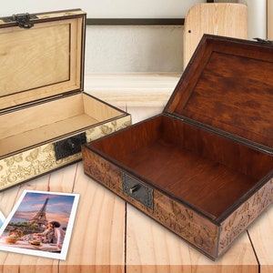 May include: Two wooden boxes with intricate carvings and brass accents. The boxes are open and empty, revealing the interior wood. The boxes are on a wooden surface.