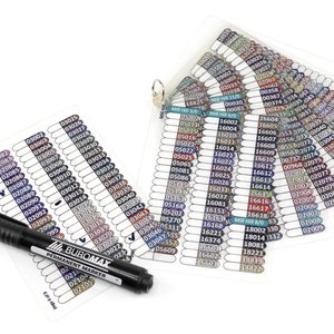 May include: A set of color swatches for permanent markers, organized in a fan-like display. The swatches are labeled with numbers and arranged in rows. A black permanent marker with the brand name "BUROMAX" is included.