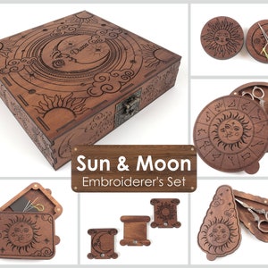 Pode incluir: Um conjunto de bordado de madeira com tema de sol e lua. O conjunto inclui uma caixa grande com tampa articulada, uma caixa redonda com tampa articulada, uma caixa retangular pequena com tampa articulada e dois porta-bobinas. As caixas são decoradas com entalhes intrincados do sol, da lua e das estrelas. O conjunto também inclui um par de tesouras de bordado, agulhas e linha.