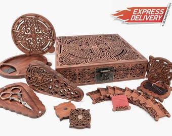 May include: A wooden sewing box with intricate Celtic knot designs. The box has a hinged lid and a latch. The box is open and contains various wooden spools, needles, and a pair of scissors.