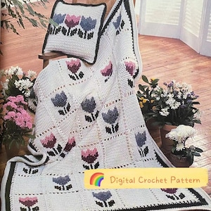 May include: A white crochet blanket and pillow set featuring a floral pattern in shades of purple, blue, and black. The blanket and pillow are displayed on a wooden chair. The text "Digital Crochet Pattern" is visible.