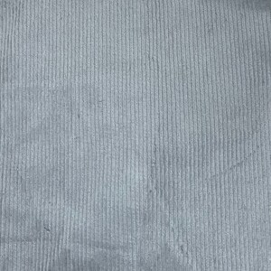 May include: A close-up of a gray corduroy fabric with a vertical ribbed texture.