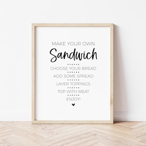 May include: A white sign with black text that reads "Make your own Sandwich" with instructions to choose your bread, add some spread, layer toppings, top with meat, and enjoy.