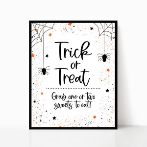 May include: A white printable sign with black text that says "Trick or Treat" and "Grab one or two sweets to eat!" The sign is decorated with black spiderwebs, orange stars, and black spiders.