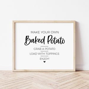 May include: A white sign with black text that reads "Make your own Baked Potato. Grab a potato. Load with toppings. Enjoy!" with a small black heart at the bottom.