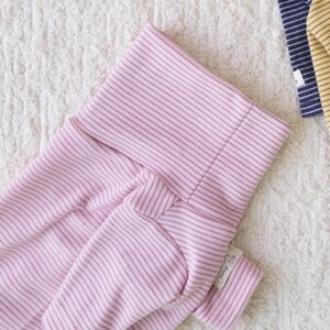 May include: Pink striped baby onesie with a white tag that says "Mommy & Me".