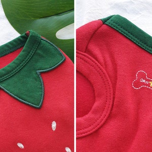 Pode incluir: Camiseta vermelha para cachorro com um design de morango verde e um osso branco com o texto "GRAWLICHE" nas costas.