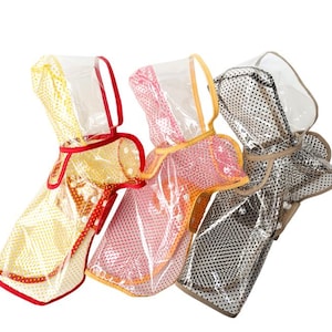 Könnte beinhalten: Drei transparente Regenmäntel für Haustiere mit Punktemustern in Gelb, Pink und Schwarz. Jeder Regenmantel verfügt über eine Kapuze, farblich abgestimmte Ränder und Druckknöpfe auf der Vorderseite für einen sicheren Sitz.