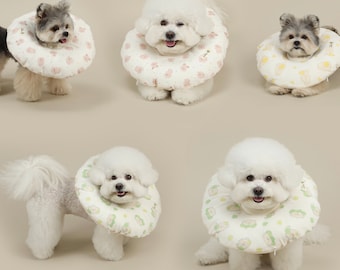 May include: Five dogs wearing soft, padded, printed dog collars. The collars are designed to protect the dog's skin from scratching and licking after surgery or injury. The collars are available in a variety of colors and patterns.