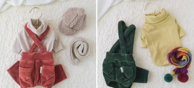 May include: Two sets of pet clothing, one with a red corduroy overall and a striped turtleneck, and the other with a green corduroy overall and a yellow striped turtleneck.