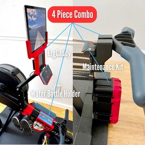 Puede incluir: Un combo de 4 piezas para una máquina de remo, que incluye un soporte para tableta, un portavasos, un kit de mantenimiento y un ErgCaddy. El soporte para tableta es rojo y negro, el portavasos es rojo, el kit de mantenimiento es negro y rojo, y el ErgCaddy es negro.