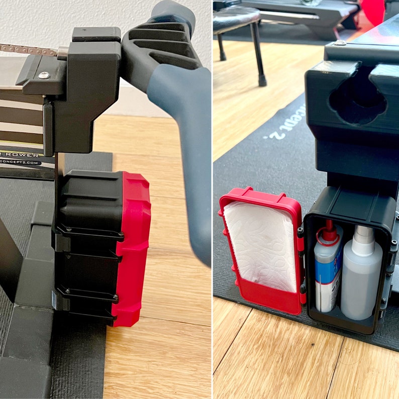May include: A black and red storage box attached to a Concept2 rowing machine. The box is open, revealing a roll of white paper towels and two bottles of cleaning solution. The rowing machine has a gray handle.