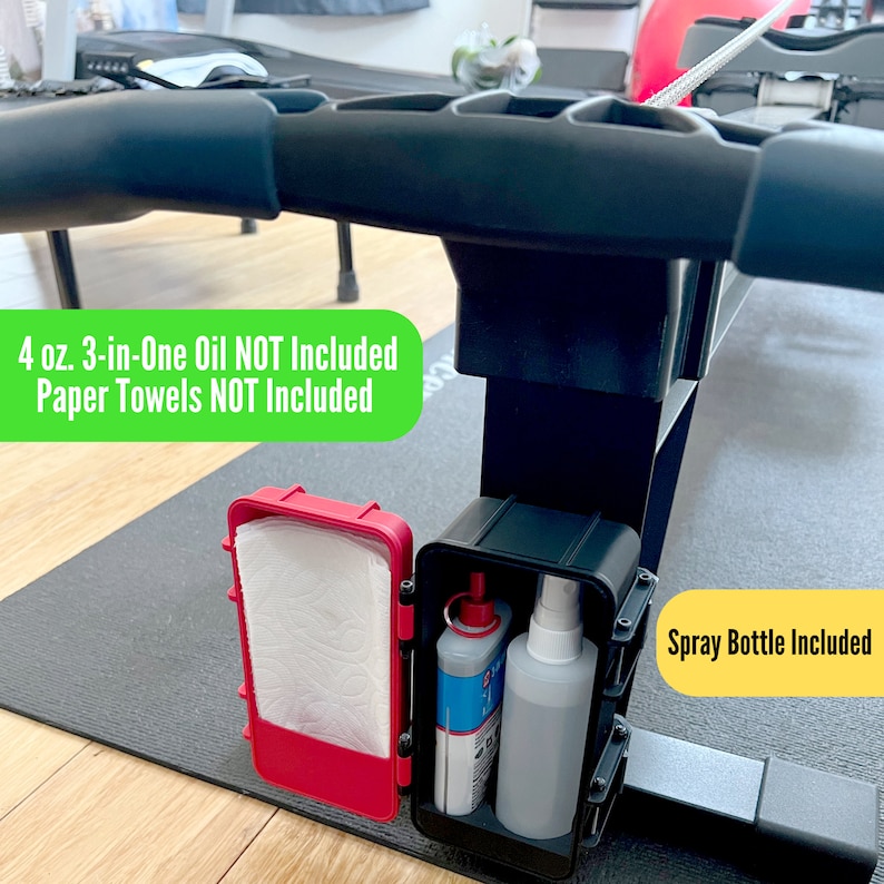 May include: A black exercise machine with a red container holding paper towels and a black container with a spray bottle and a bottle of oil. The text on the image says "4 oz. 3-in-One Oil NOT Included Paper Towels NOT Included Spray Bottle Included."