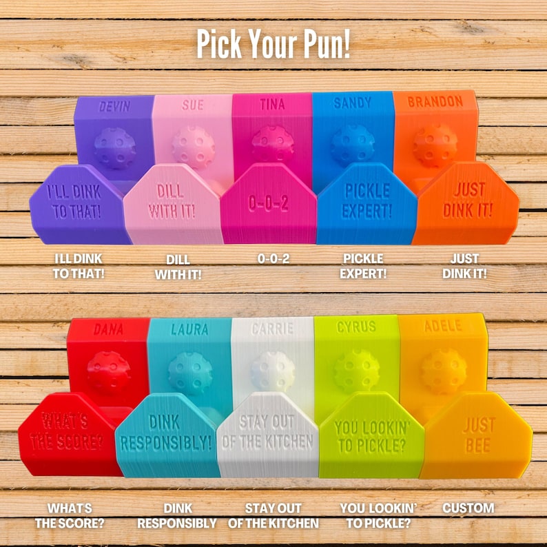 Op de afbeelding: Een verzameling kleurrijke pickleball-thema cadeaus met woordspelingen, waaronder "I'll Dink to That!" en "Just Dink It!". De items zijn in verschillende kleuren zoals paars, roze, blauw en oranje, met een pickleball-ontwerp. De tekst "Pick Your Pun!" staat bovenaan.