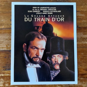 Peut inclure: Affiche de film pour le film "La Grande Attaque du Train d'Or" avec Sean Connery, Donald Sutherland et Lesley-Anne Down. L'affiche présente une image dramatique des deux acteurs principaux, avec un train en arrière-plan.
