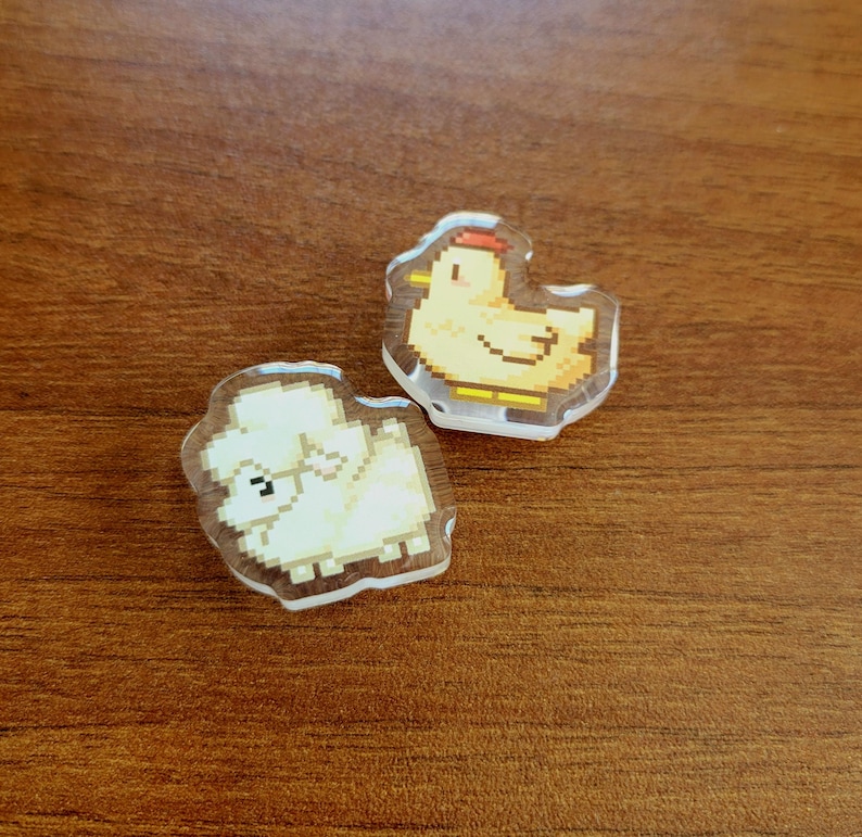 Two shoe charms sitting on a desk. The two charms are sheep and chicken