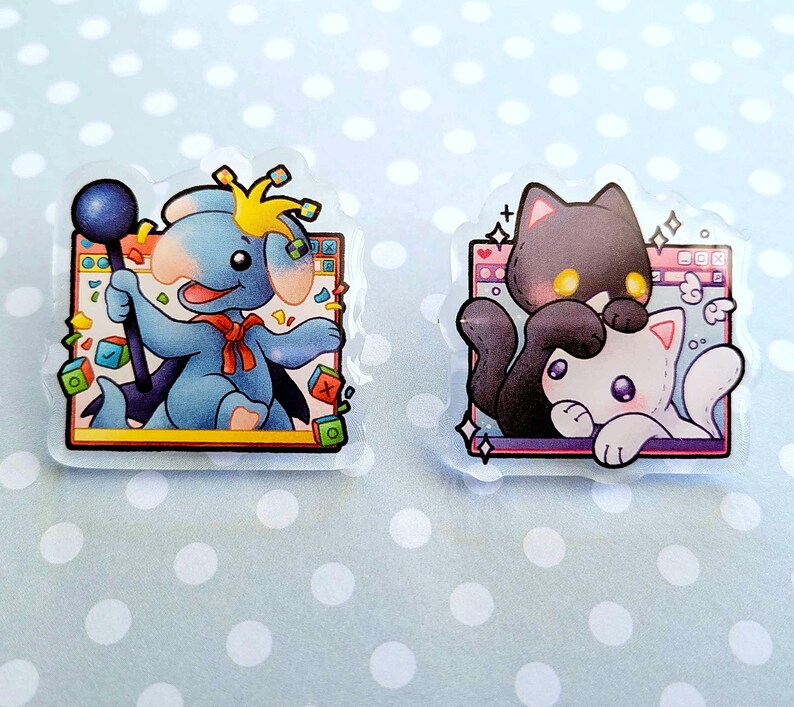 May include: Two clear stickers with cartoon illustrations. One features a blue elephant-like character with a staff and crown. The other shows a black cat and a white cat. Both stickers have a decorative border.