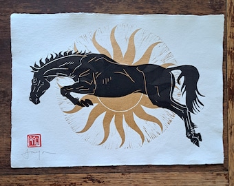 Sun Horse. Original linocut print of a black horse jumping in front of a golden sun A3 size 11.7 x 16.5 inches on handmade cotton rag paper.