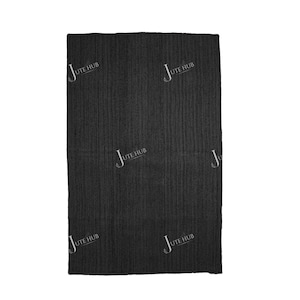 May include: A rectangular black area rug featuring a textured, woven surface with vertical lines. The text JUTE HUB is printed in white at multiple intervals across the surface of the rug, which has a consistent dark colour and a flat, woven construction.