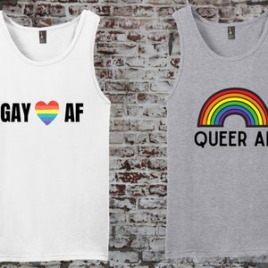 May include: Two tank tops with pride-themed designs. The white tank top has the text "GAY ♥ AF" with a rainbow heart. The gray tank top has a rainbow arc and the text "QUEER AF".