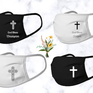 May include: Four face masks with a cross design. Two masks are black with white crosses and two masks are white with black crosses. The masks have the text "God Bless" and a name on them.
