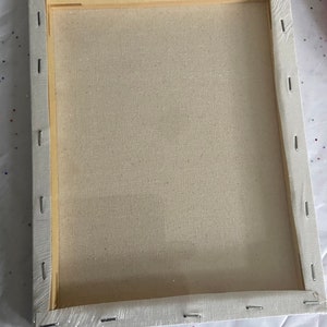 K&ouml;nnte beinhalten: Eine leere Leinwand, die auf einem Holzrahmen gespannt ist und zum Malen bereit ist. Die Leinwand ist wei&szlig; und der Rahmen ist aus Naturholz.