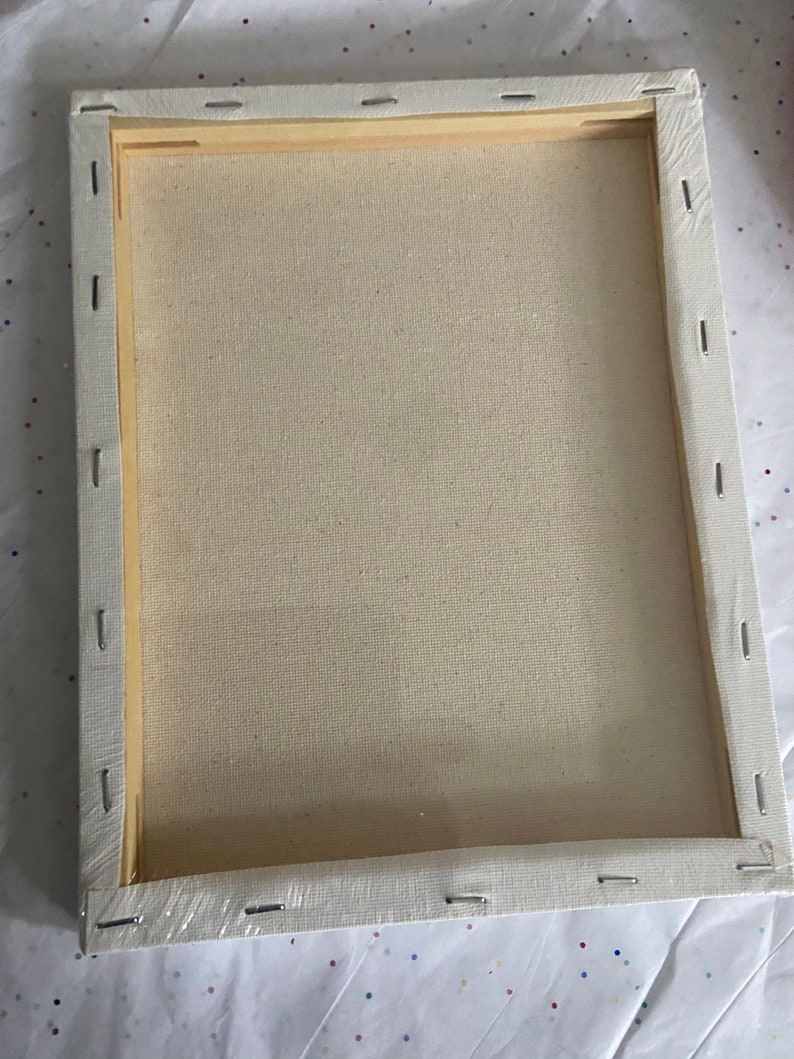 K&ouml;nnte beinhalten: Eine leere Leinwand, die auf einem Holzrahmen gespannt ist und zum Malen bereit ist. Die Leinwand ist wei&szlig; und der Rahmen ist aus Naturholz.