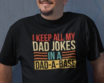May include: A black t-shirt with a vintage-style graphic that reads "I keep all my dad jokes in a dad-a-base".