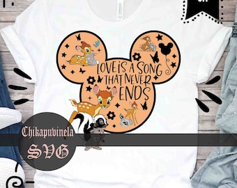 Puede incluir: Una camiseta blanca con un diseño de cabeza de Mickey Mouse de color melocotón. El diseño incluye a Bambi y Tambor de la película de Disney Bambi, junto con el texto "Love is a song that never ends".