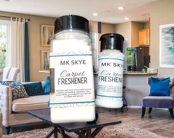 May include: Two white plastic bottles with black lids and labels that say "MK SKYE Carpet Freshener". The bottles are sitting on a wooden table in a living room. The text on the label says "Removes odor from various areas such as carpets, pet bedding, upholstery, litter boxes, shoes, gym bags and cars. Sprinkle on carpet and vacuum."