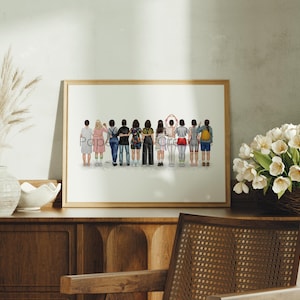 May include: A framed print showing a group of people from behind, each wearing different clothing. The artwork is set against a plain background, and the frame is a light brown colour.
